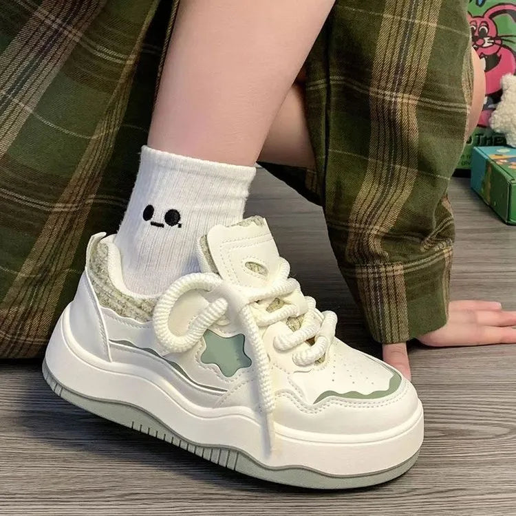 Women's green patent leather platform sneakers with front lace-up closure and rubber sole