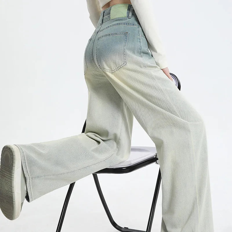 Gradient blue women's straight-leg denim trousers on a hanger, showing colour transition.