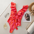 Women's printed one-piece swimsuit with ruffles on both shoulders and a deep V-neck with mesh stitching.