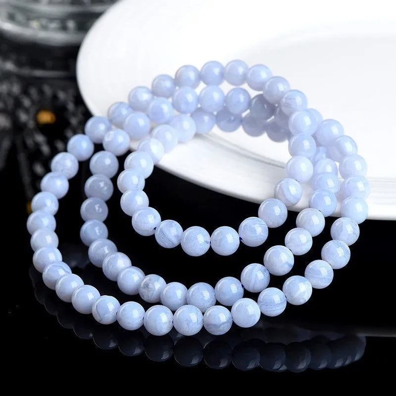 Blue agate bracelet with multi-circle pattern and scattered striped beads on a wrist.