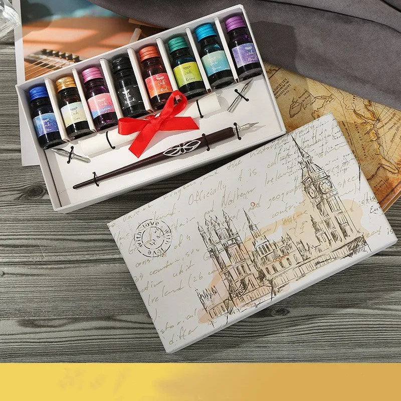 Wooden dip pen, coloured ink bottles, and nibs arranged inside a wooden gift box for calligraphy.