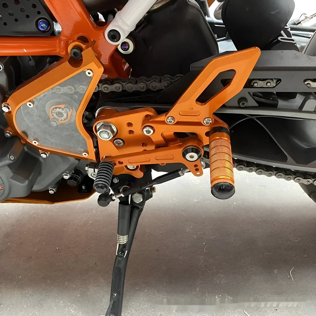 KTM Duke motorcycle raised footpeg support assembly in black and orange colours