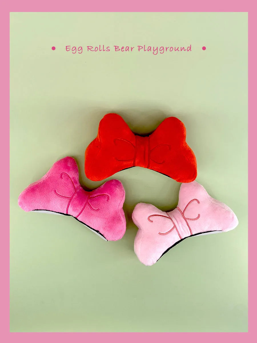 Soft plush decorative bow for clip-on attachment to a motorcycle or ski helmet.