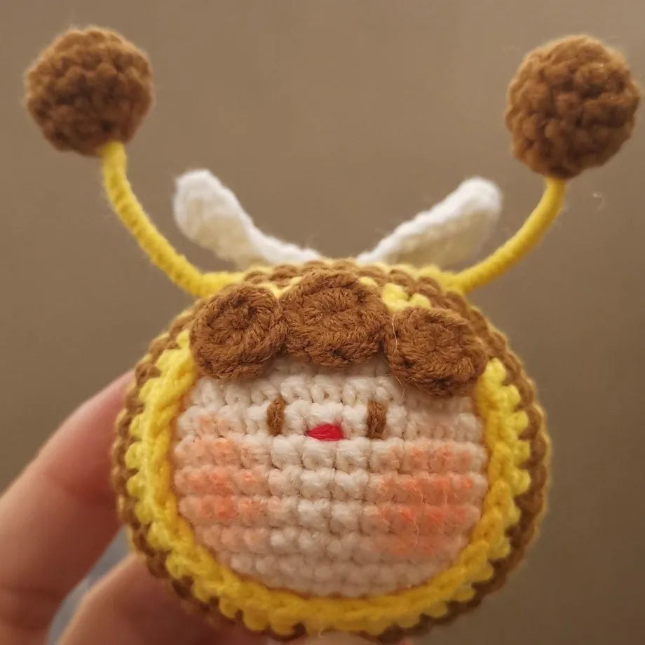 Handmade crocheted plush bee hive and bees accessory for woolen dolls on a white background.