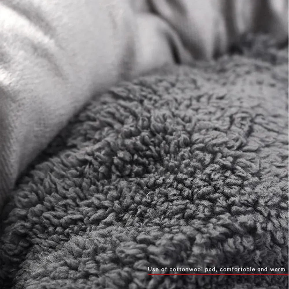 Grey round plush pet bed with pillow for small dogs and cats on a wood floor.