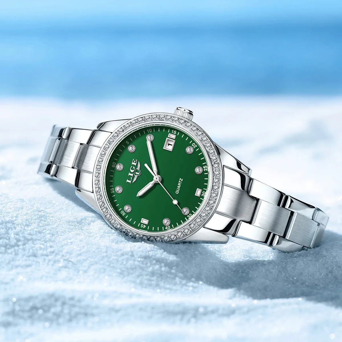 Women's silver fashion watch with diamond bezel, round white dial, luminous hands, and stainless steel bracelet.