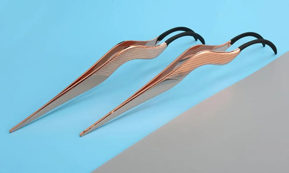 Rose gold metal false eyelash curler aid tool on plain background