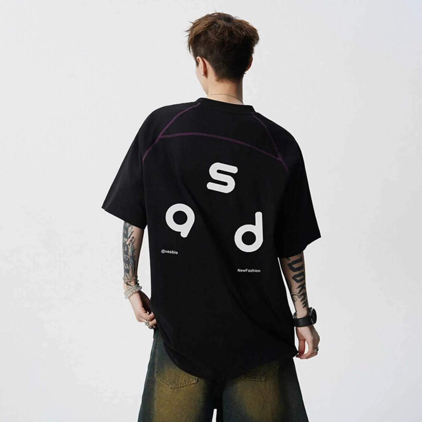 A loose-fit black cotton T-shirt with a white letter print on the front, showing a round neck and short sleeves.