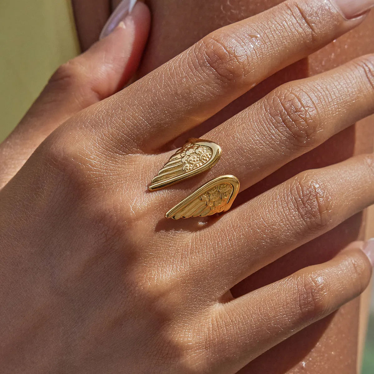 Adjustable stainless steel Wings ring with a wings motif, shown in an electroplated gold finish.