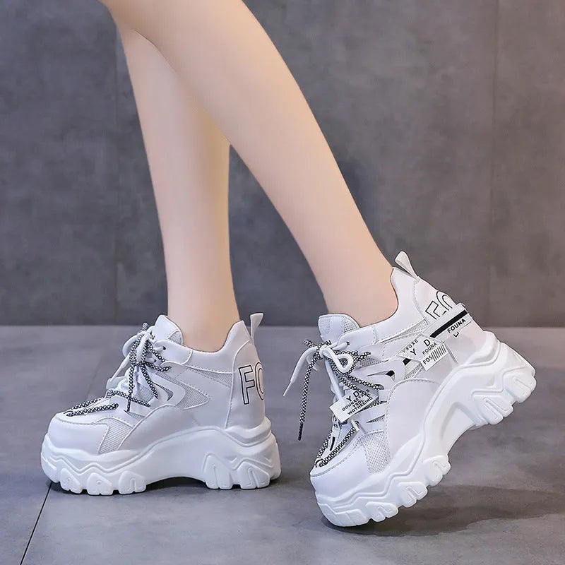 Women's white and black platform tennis shoes with mesh upper and cross-strap.