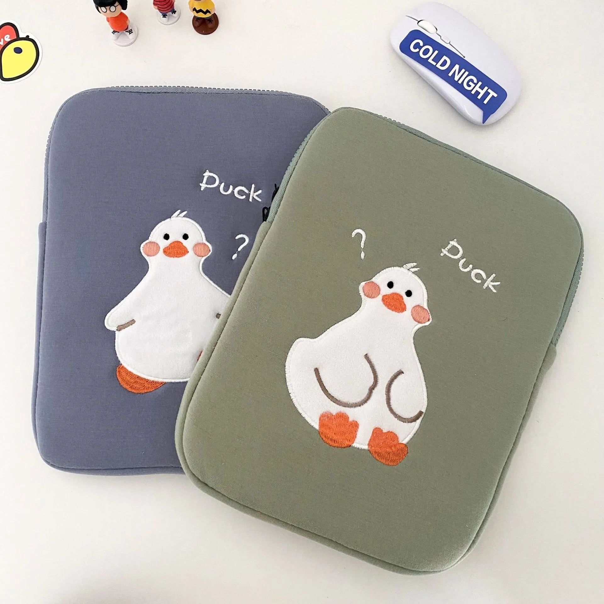 Blue cotton iPad case with embroidered cartoon duck design and a zipper.