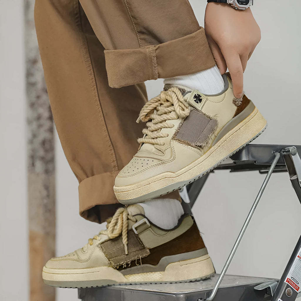 Beige low-top skateboard shoes with microfiber upper and flat rubber sole on white background