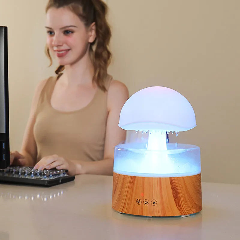 White cloud-shaped ultrasonic humidifier producing rainfall mist with colour-changing night light effects