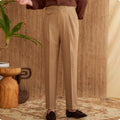 Men's slim fit straight leg trousers in dark grey, light brown, and light apricot colours on a hanger.