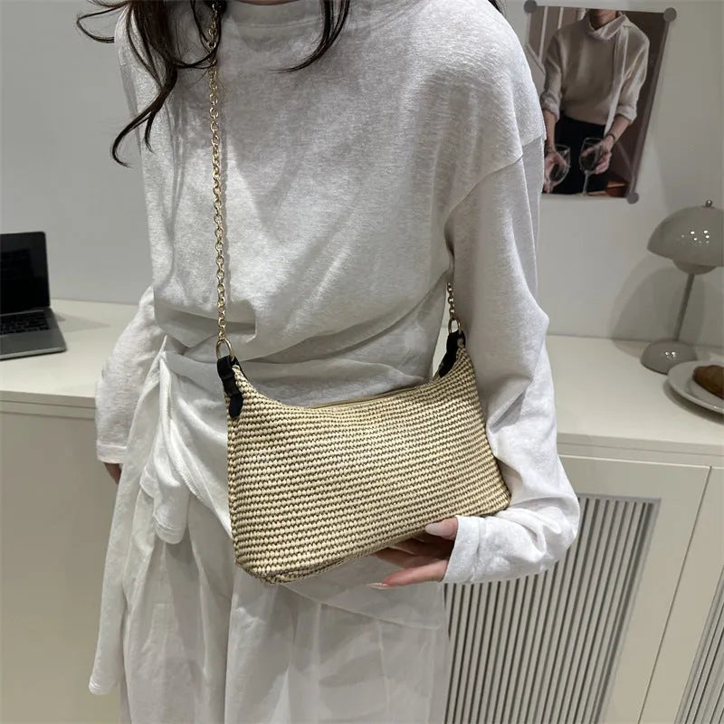 Khaki straw woven horizontal square tote bag with shoulder straps and outer sandwich pocket.