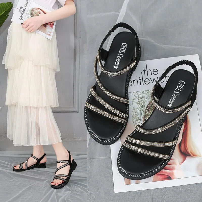 Women's flat silver sandals with round toe, rhinestone details, and an elastic strap.