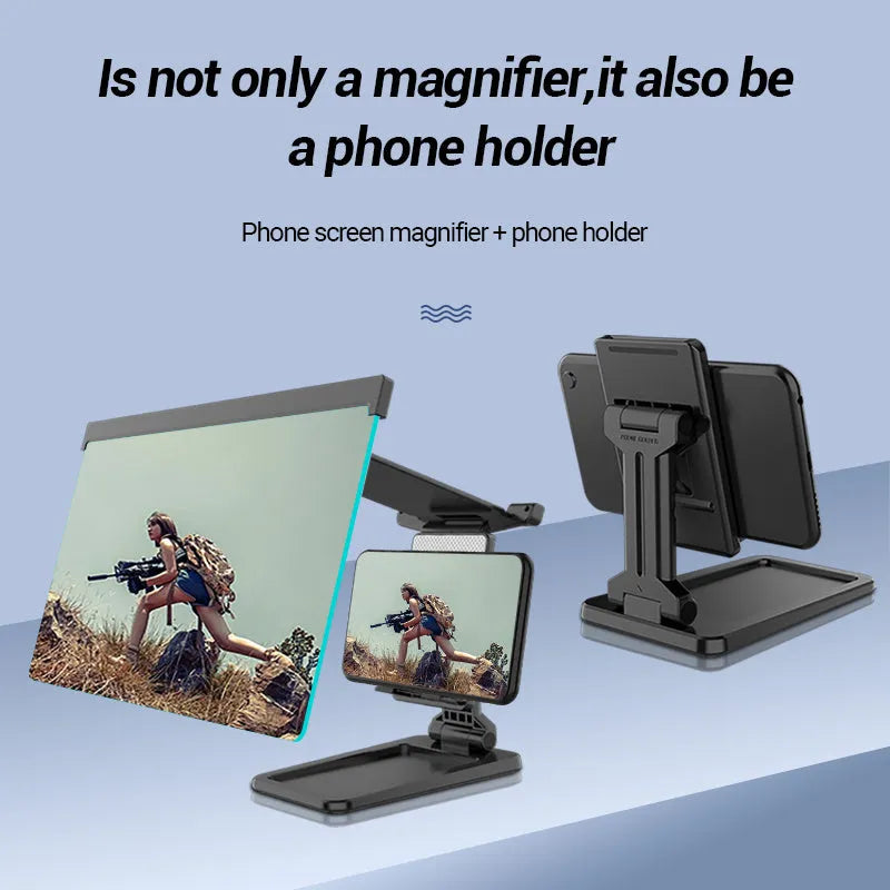 Black detachable mobile phone screen magnifier and holder set up on a desk, showing a phone displaying a magnified movie scene.