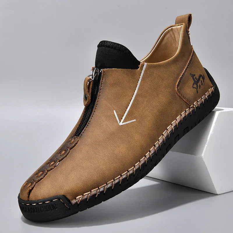 Men's brown leather-look zip-up ankle boots with hand-stitched detailing on a white background.