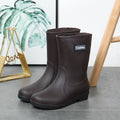 Women's mid-calf PVC rain boots in black, shown with a low heel and optional warm lining.