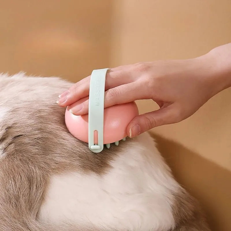 A blue silicone pet bathing brush with soft bristles and a palm-grip base for washing dogs and cats.