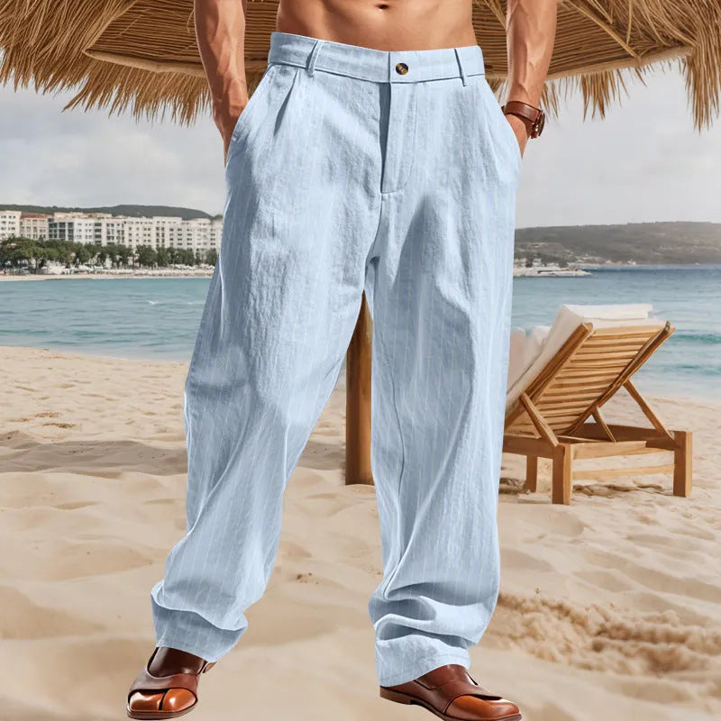 Man wearing loose-fit high-waist striped linen trousers in a light blue colour.