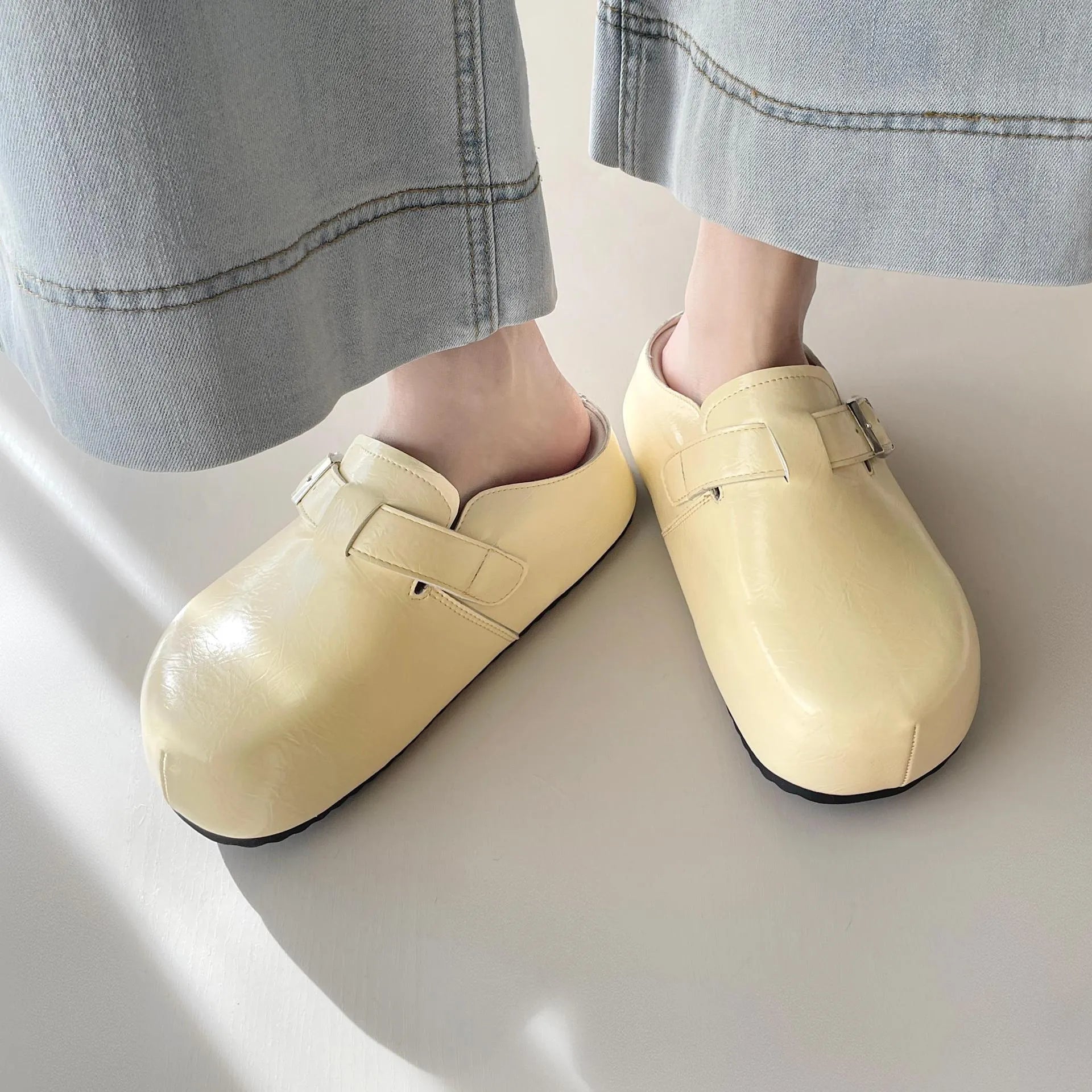 Flat round-toe casual sneakers with a metal buckle on the PU upper.