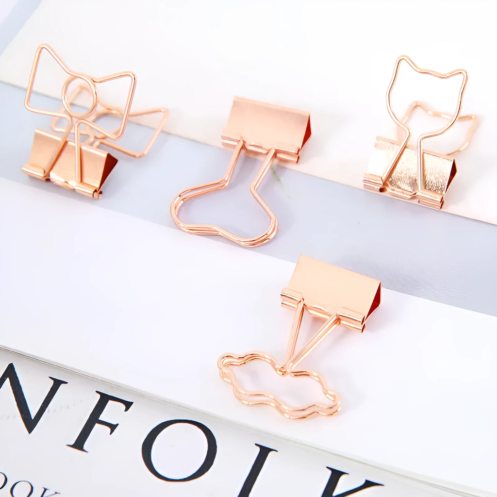 Small gold metal office clip with long tail, showing flamingo, love, cloud, cat, cactus, and bow shape options.