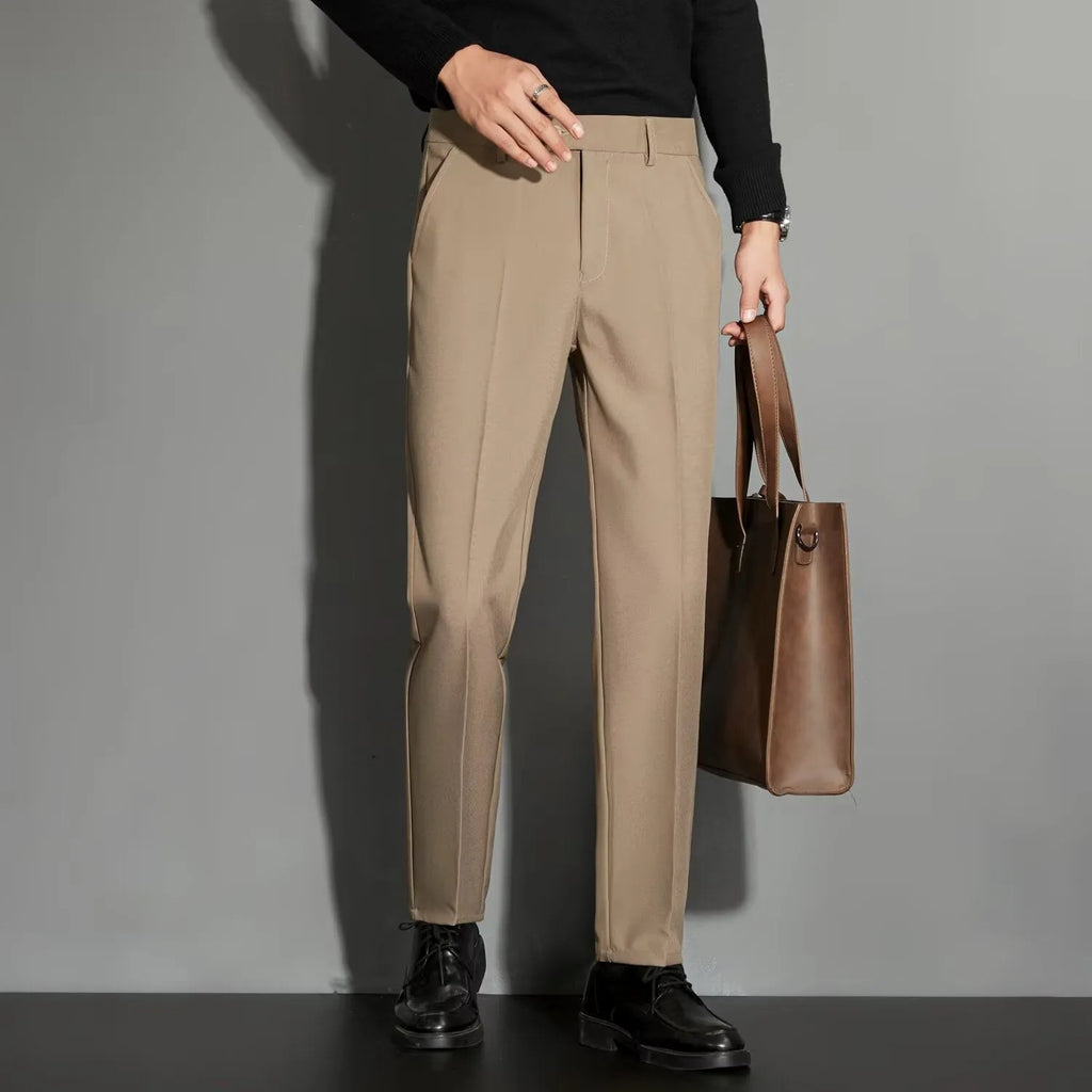 Men's straight-leg ankle-length suit trousers in a light colour showing spring draping effect detail.