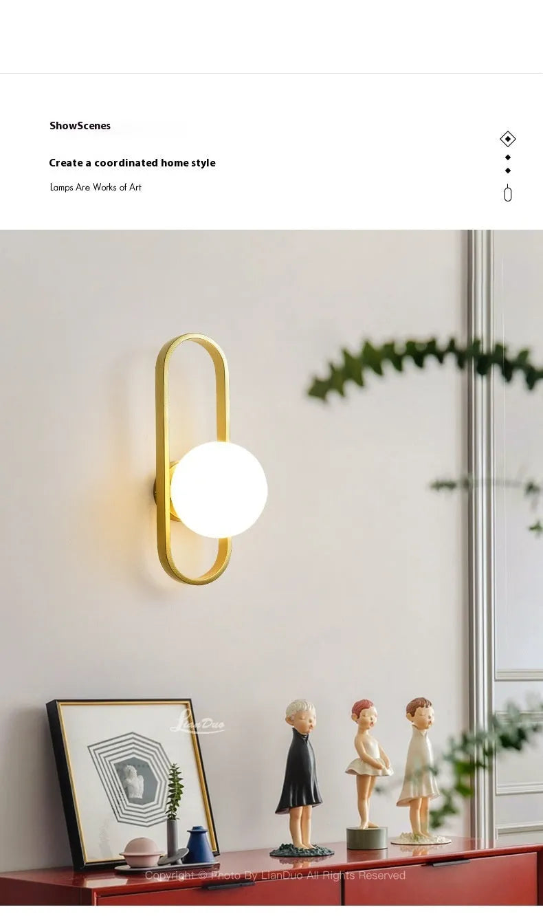 Minimalist black iron wall lamp with a glass shade mounted on a white wall.
