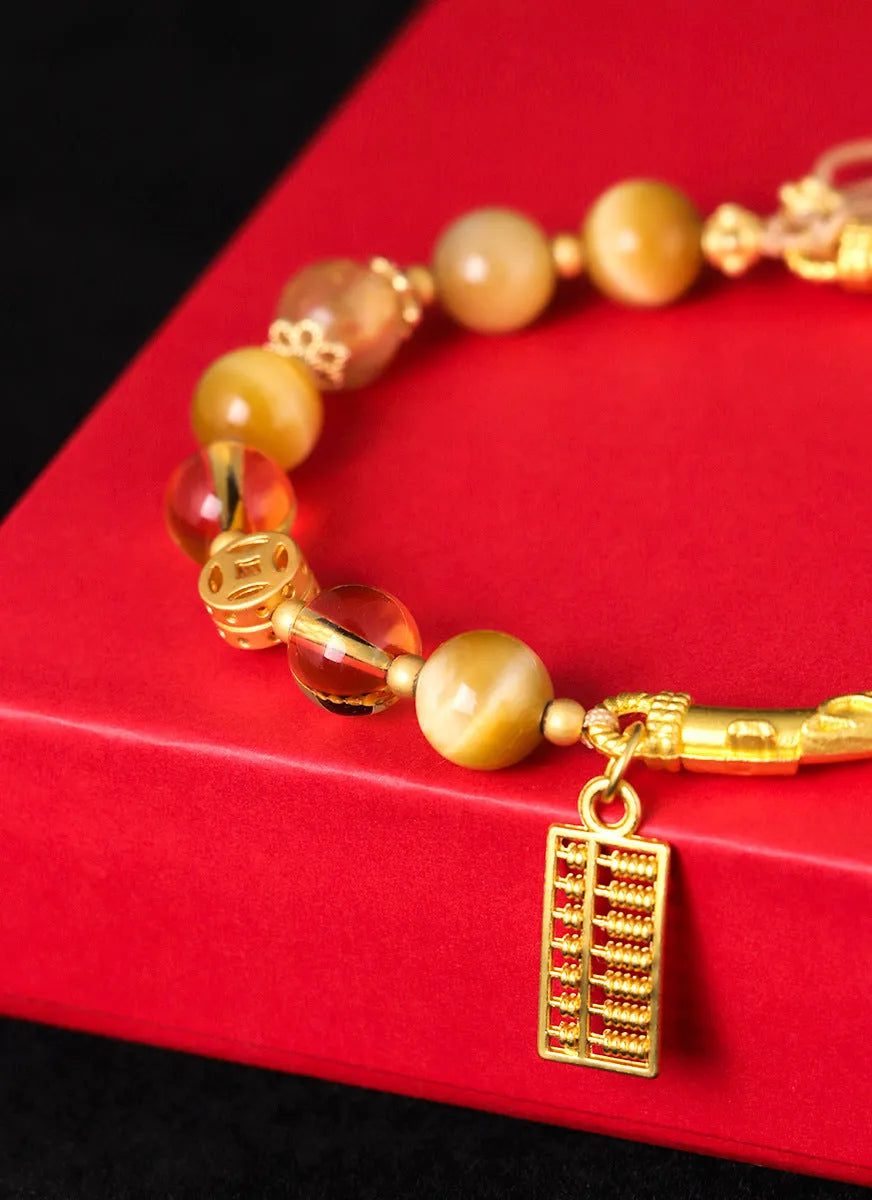 Handmade beaded bracelet featuring tigereye and citrine stones with yellow tower crystal and diamond-shaped copper parts