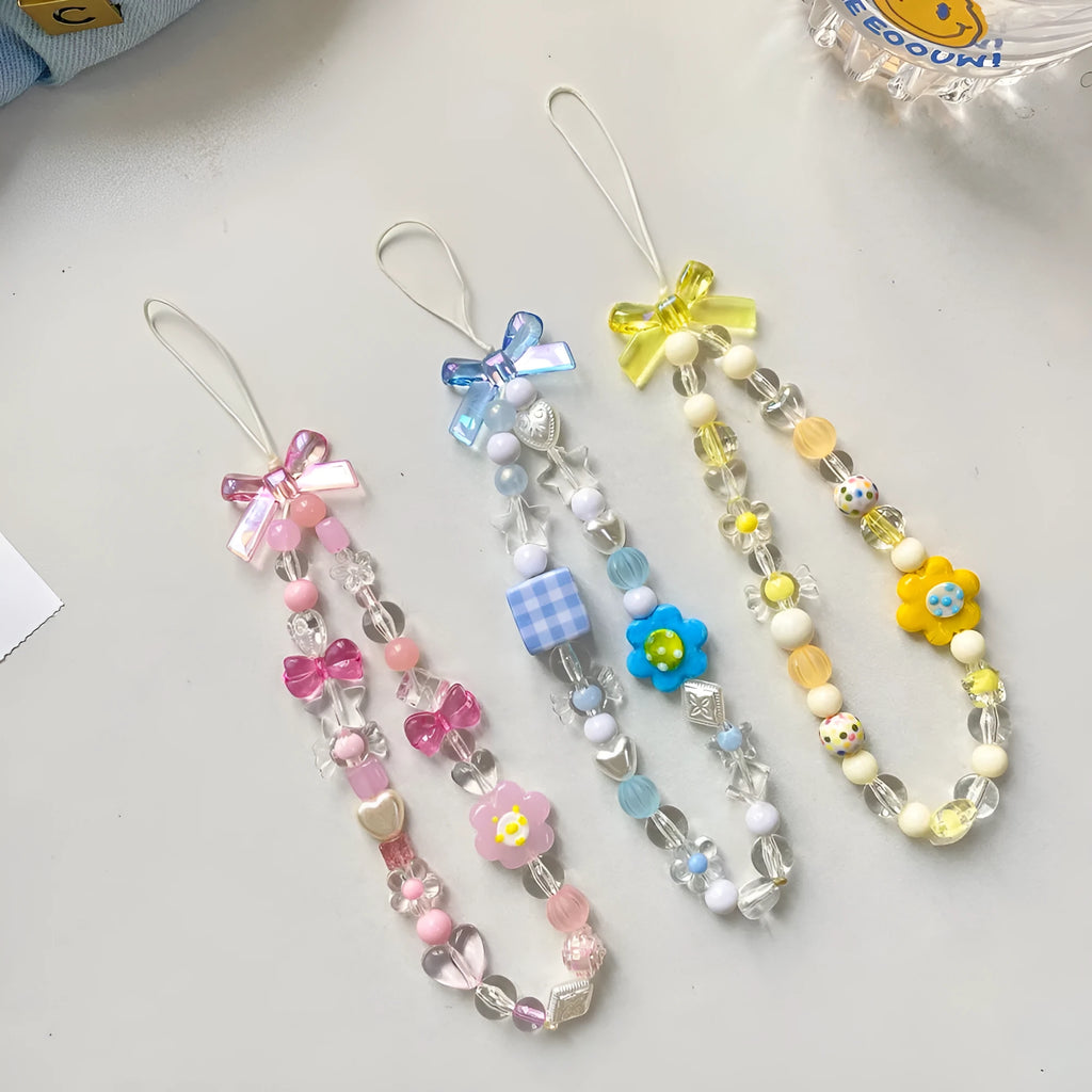 Colourful beaded flower lanyard for mobile phones with blue, pink, or yellow plastic flowers on an adjustable rope strap.