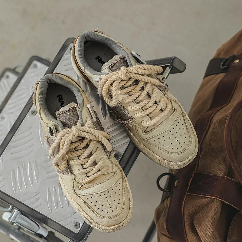 Beige low-top skateboard shoes with microfiber upper and flat rubber sole on white background