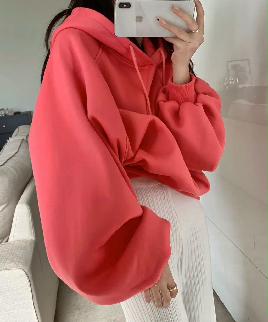 Watermelon red women's sleeveless silk hooded sweater on a hanger showing loose fit and hood detail.