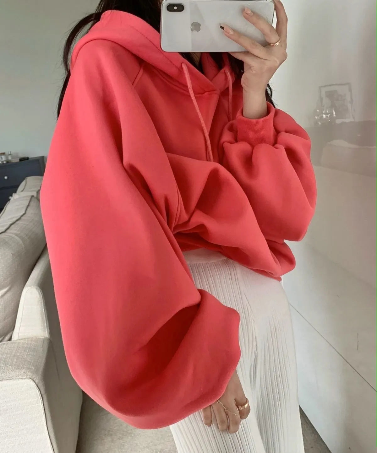 Watermelon red women's sleeveless silk hooded sweater on a hanger showing loose fit and hood detail.