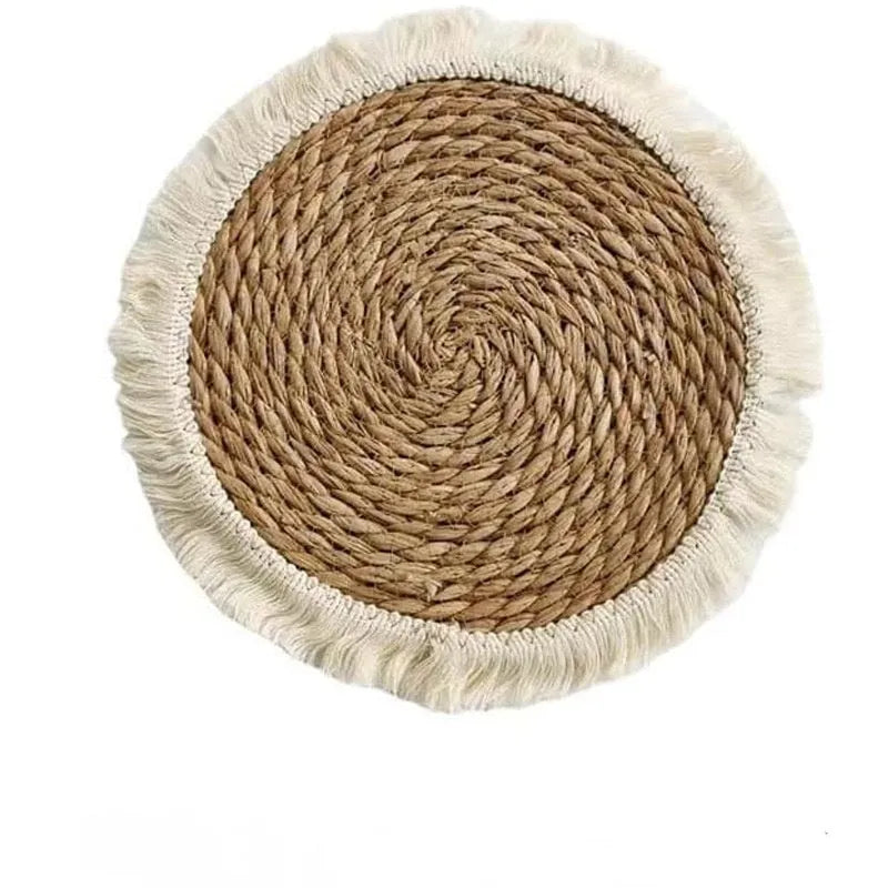 Round natural papyrus placemat on a wooden table, showing corn rope tassel detail and modern minimalist style.