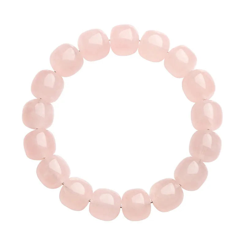 Close-up of a pink crystal bracelet with barrel-shaped beads on a wrist.