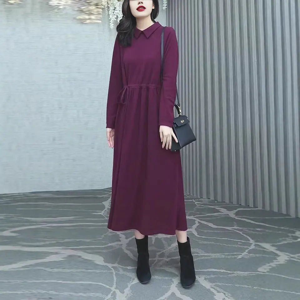 A purplish red plus size long sleeve midi dress for women, shown in an urban style.