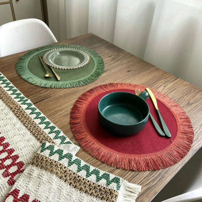 Handwoven round jute placemat with tassel edge in original hemp colour on a wooden table