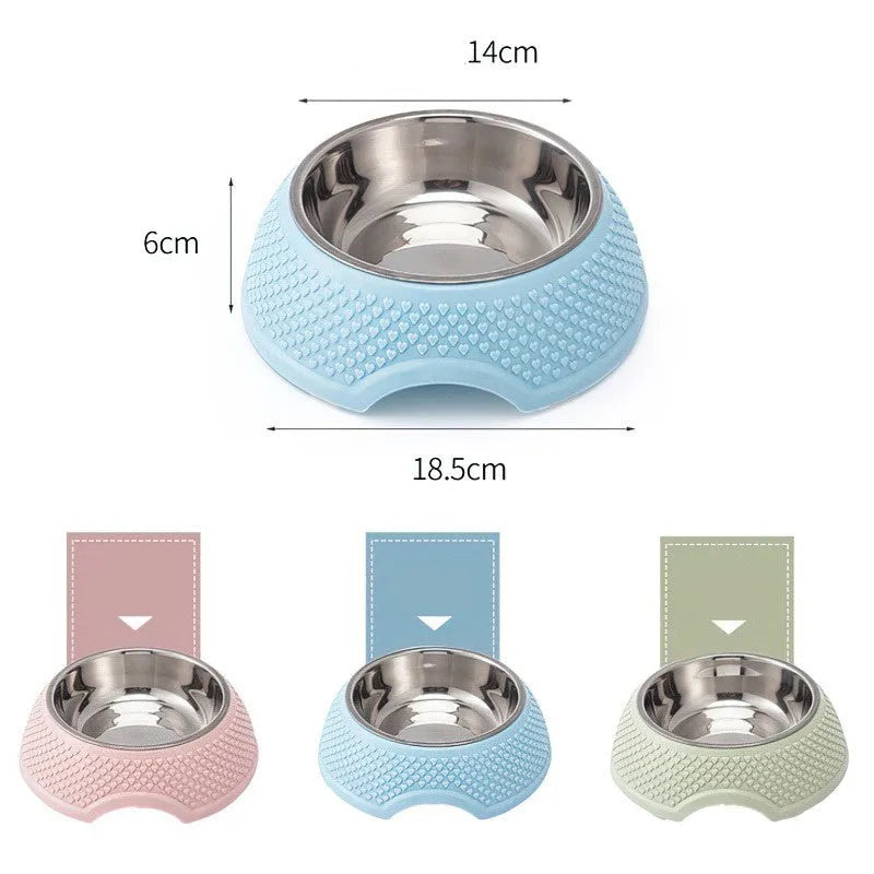 Set of four coloured stainless steel pet bowls with non-slip bases on a table.