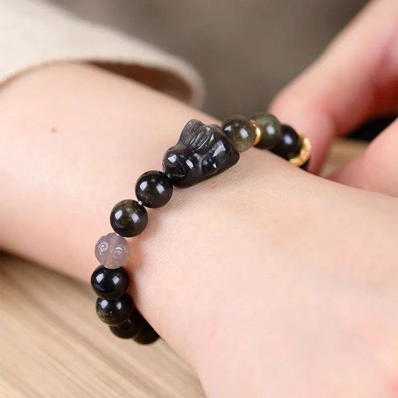 Handmade obsidian bracelet with lying rabbit charm, grey agate beads and brass metalwork in national style