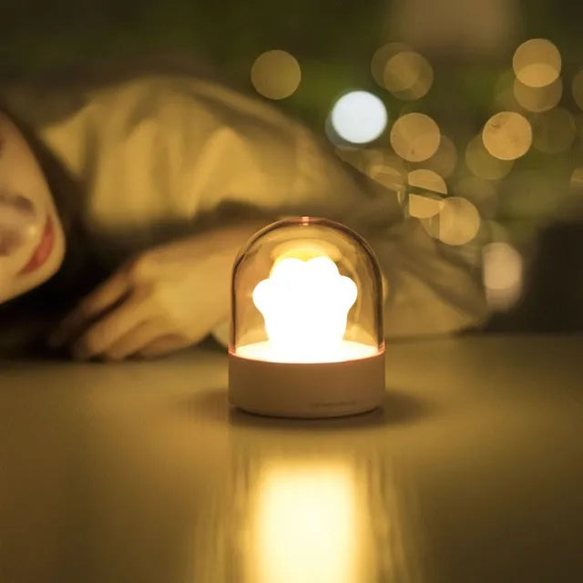 Grey cat paw shaped USB rechargeable night light with musical features on wooden desk