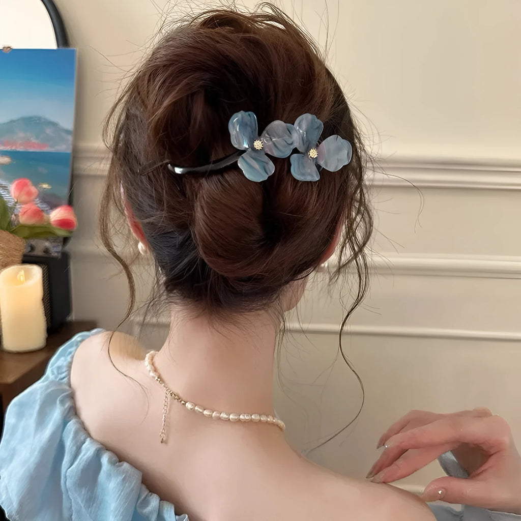Close-up of a retro-style floral bobby pin with coloured acrylic petals.