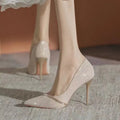 Women's black stiletto high heels with pointed toe and oversleeve design on a white background.