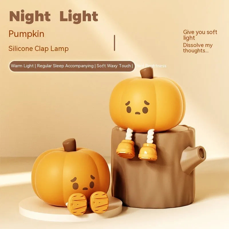 Soft orange silicone pumpkin-shaped night light with a warm glowing face on a table.