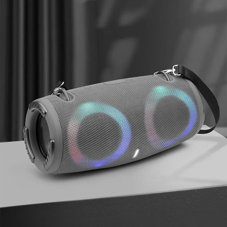 War Drum portable Bluetooth speaker with coloured RGB lights on a table outdoors.