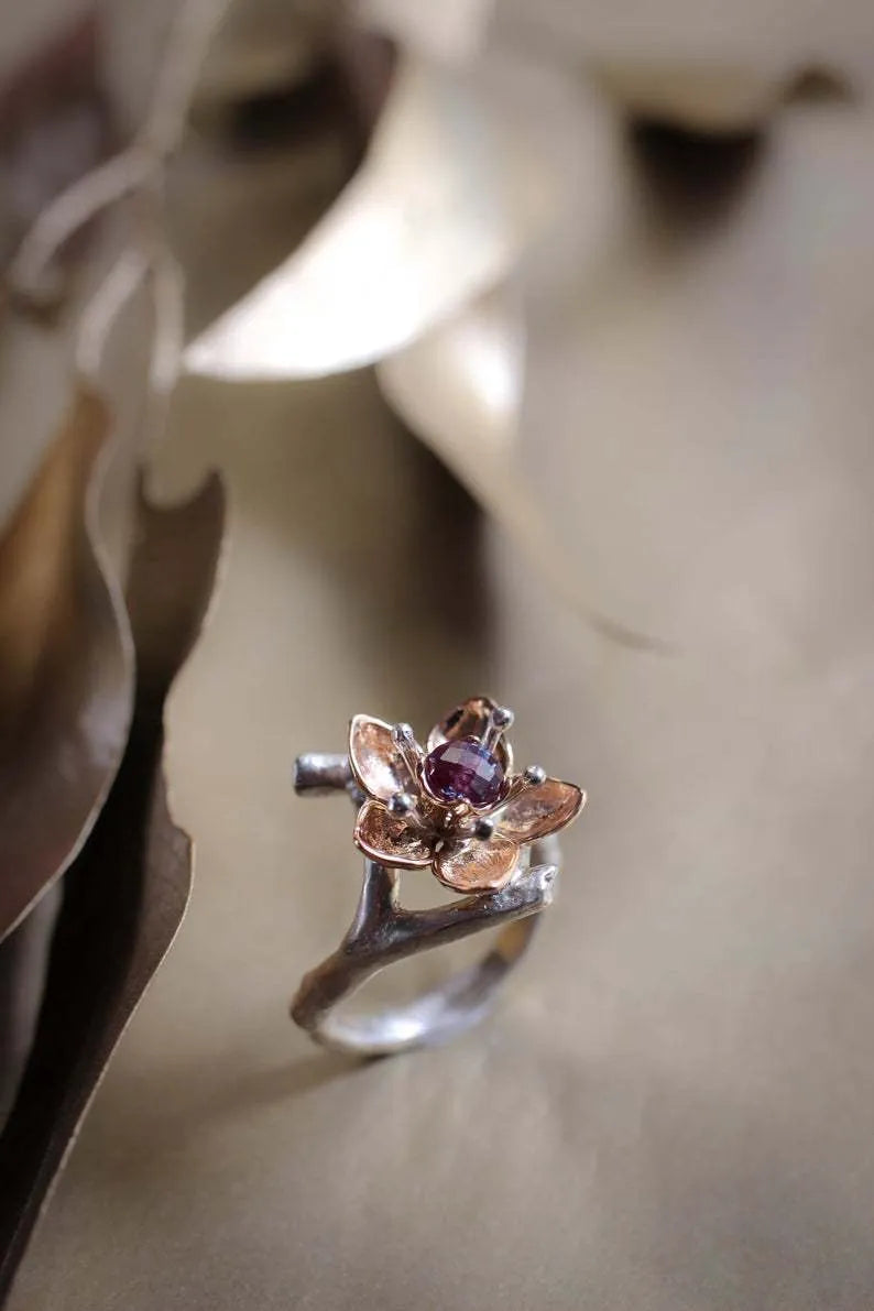 Silver two-tone women's alloy ring with a geometric floral design on a plain background.