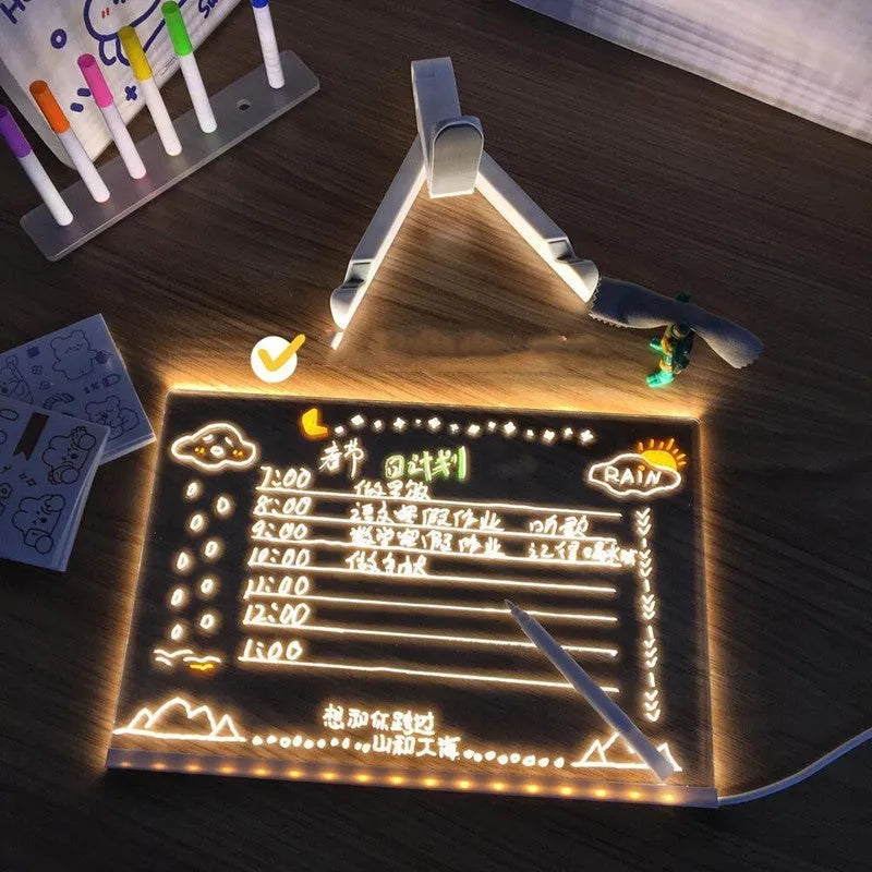 Acrylic LED message board night light on a desk with colourful handwritten notes glowing softly.