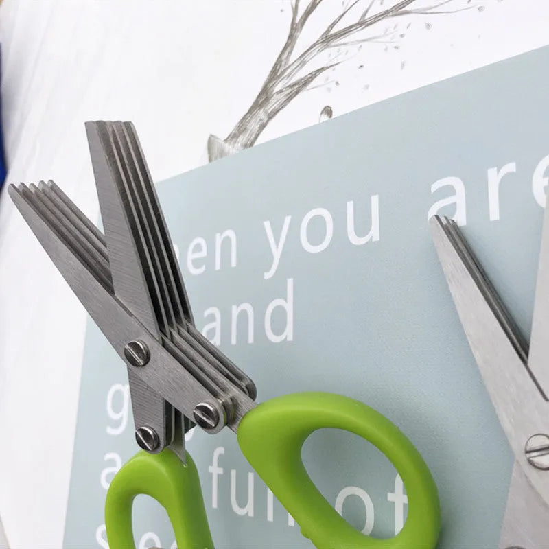 Stainless steel multi-layer herb scissors with green handles for chopping green onions and seaweed.