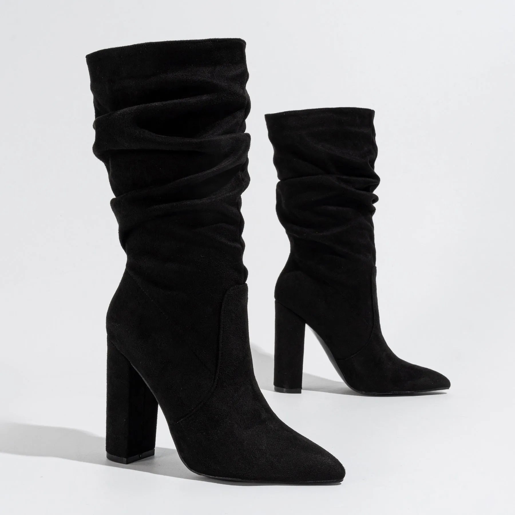 Women's black suede pointed-toe boots with a chunky high heel and mid-calf length