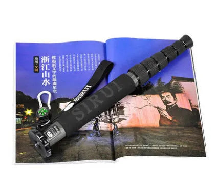 Black carbon fibre telescopic camera monopod fully extended next to a DSLR.
